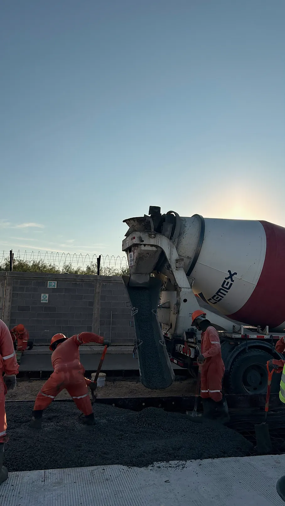 Colado de una vialidad de concreto hidráulico en la Estación Anzalduas: una revolvedora descarga mientras la cuadrilla extiende el concreto