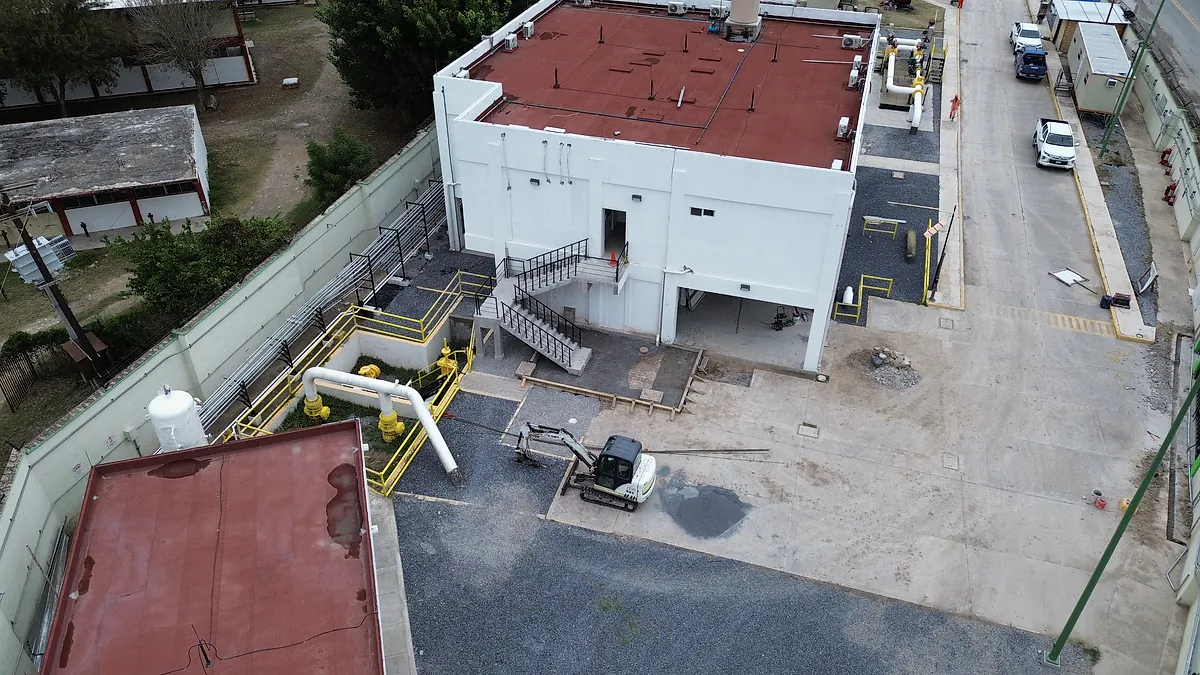 Vista aérea del edificio de la Terminal 02, con escalera exterior, rampas con barandal amarillo y una miniexcavadora en el patio