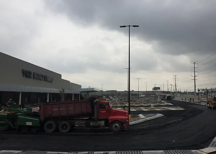 Pavimentación del estacionamiento de Home Depot Lincoln, en Monterrey: camión de volteo y pavimentadora frente a la tienda