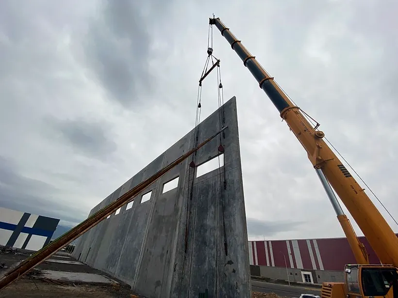 Muro de concreto izado con una grúa telescópica en la Nave Rochester, en Ramos Arizpe