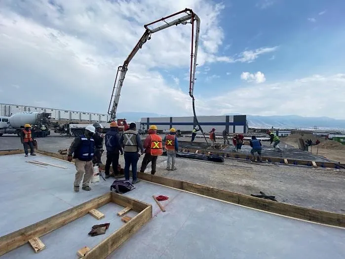 Cuadrilla colando con bomba pluma los paneles de concreto en el piso de la Nave Rochester